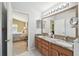 Main bathroom featuring a double vanity, framed mirrors, and an ensuite bedroom at 11637 Spindrift Loop, Hudson, FL 34667