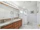 Main bathroom featuring a double vanity, framed mirrors, and a glass-enclosed shower at 11637 Spindrift Loop, Hudson, FL 34667