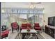 Sunroom with tile floors, vertical blinds, and seating, plus a ceiling fan at 11637 Spindrift Loop, Hudson, FL 34667