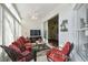 Sunroom with tile flooring, vertical blinds, seating, TV, and ceiling fan at 11637 Spindrift Loop, Hudson, FL 34667