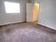 A simplistic bedroom with neutral walls, carpet flooring, and a window providing natural light at 11715 Boynton Ln # 74B, New Port Richey, FL 34654