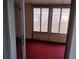 Enclosed Florida room with sliding windows and red carpet at 11715 Boynton Ln # 74B, New Port Richey, FL 34654