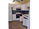 Functional kitchen features white cabinets, black appliances, and practical layout at 11715 Boynton Ln # 74B, New Port Richey, FL 34654