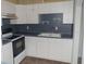 Traditional kitchen featuring white cabinets, a double basin sink, black appliances, and functional layout at 11715 Boynton Ln # 74B, New Port Richey, FL 34654