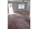 Open-concept living room features large windows and access to the outdoors at 11715 Boynton Ln # 74B, New Port Richey, FL 34654
