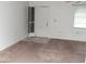 Neutral carpeted living room, featuring a screen door, bright natural light from the window, and simple design at 11715 Boynton Ln # 74B, New Port Richey, FL 34654