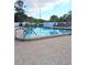 A refreshing community pool is surrounded by comfortable lounge chairs and lush landscaping at 11715 Boynton Ln # 74B, New Port Richey, FL 34654