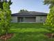 Wide view of the backyard with manicured grass and a covered patio at 12064 Cradock St, Spring Hill, FL 34608