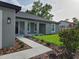 Welcoming front entrance featuring a landscaped walkway leading to a stylishly designed home at 12064 Cradock St, Spring Hill, FL 34608