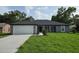Beautiful one-story home with a manicured lawn and a two car garage at 12064 Cradock St, Spring Hill, FL 34608