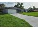 Beautifully renovated single-story home showcasing a lush lawn, and a convenient two-car garage at 12064 Cradock St, Spring Hill, FL 34608