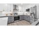 Modern kitchen boasts stainless steel appliances, gray cabinetry, and white subway tile backsplash at 12064 Cradock St, Spring Hill, FL 34608