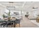 Open-concept living space features a modern kitchen, dining area, and comfortable seating with light wood flooring at 12064 Cradock St, Spring Hill, FL 34608