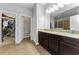 Bright bathroom with granite counters, dual sinks, and a view of the walk-in closet at 1236 Ketzal Dr, Trinity, FL 34655
