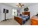 Cozy bedroom featuring a wooden bed frame, ceiling fan, and neutral carpet at 1236 Ketzal Dr, Trinity, FL 34655