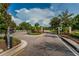 Gated entrance to community with signage and landscaped median with yellow road lines at 1236 Ketzal Dr, Trinity, FL 34655
