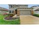Charming two-story home featuring a two-car garage, stone accents, beautiful flower beds, and a well-manicured lawn at 1236 Ketzal Dr, Trinity, FL 34655