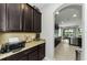 Open kitchen with granite countertops, dark cabinets, and stainless steel appliances at 1236 Ketzal Dr, Trinity, FL 34655