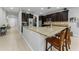 Modern kitchen featuring dark wood cabinetry, granite countertops, stainless steel appliances, and barstool seating at 1236 Ketzal Dr, Trinity, FL 34655