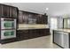 Bright kitchen featuring ample dark wood cabinets, stainless steel appliances, and a convenient breakfast bar area at 1236 Ketzal Dr, Trinity, FL 34655