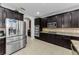 Well-equipped kitchen featuring dark wood cabinets, stainless steel appliances, and a breakfast bar with counter seating at 1236 Ketzal Dr, Trinity, FL 34655