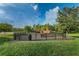 Fenced-in playground with swings, slides, and playset, surrounded by a green lawn at 1236 Ketzal Dr, Trinity, FL 34655