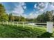 Scenic pond view with a white fence, green grass, and lush trees at 1236 Ketzal Dr, Trinity, FL 34655