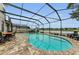A serene screened-in pool area with brick pavers, seating, and lovely lake views at 1236 Ketzal Dr, Trinity, FL 34655
