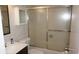 A bathroom featuring a glass shower door, white sink with wood-colored vanity, and mirrored medicine cabinet at 13012 Wedgewood Way # A, Hudson, FL 34667