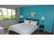 Bright bedroom with a large window, complemented by a calming blue accent wall at 13012 Wedgewood Way # A, Hudson, FL 34667