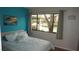 Cozy bedroom with bright accent wall and natural light from the window at 13012 Wedgewood Way # A, Hudson, FL 34667