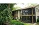 Exterior view of building featuring screened lanais, complemented by lush landscaping for added privacy at 13012 Wedgewood Way # A, Hudson, FL 34667