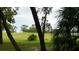 Picturesque golf course view, framed by mature trees, showcasing the lush greens and beautiful surroundings at 13012 Wedgewood Way # A, Hudson, FL 34667