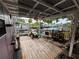 Cozy back porch overlooking waterfront with ceiling fan and weathered wood at 13626 Allyn Dr, Hudson, FL 34667