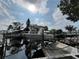 Boat in lift at wooden dock with canal and residential waterfront in background at 13626 Allyn Dr, Hudson, FL 34667