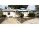 Single-story house with white trim, covered porch, mature landscaping, and concrete driveway at 13626 Allyn Dr, Hudson, FL 34667