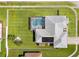 Aerial view of home featuring a screened-in pool, roof top solar panels, and fenced yard at 13627 Lightning Rod Ct, Hudson, FL 34669
