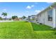 Back exterior of home with manicured lawn, screened-in pool area, and white picket fence at 13627 Lightning Rod Ct, Hudson, FL 34669
