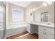 Bright bathroom featuring a soaking tub under a window and double sink vanity with great lighting at 13627 Lightning Rod Ct, Hudson, FL 34669
