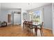 Charming dining area featuring wood floors, a chandelier, and a large window with backyard views at 13627 Lightning Rod Ct, Hudson, FL 34669