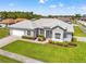 Charming single-story home with a well-manicured lawn, white picket fence, and attached two-car garage at 13627 Lightning Rod Ct, Hudson, FL 34669