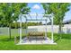 Charming outdoor picnic area with pergola cover and string lights in fenced backyard at 13627 Lightning Rod Ct, Hudson, FL 34669