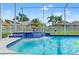 A close view of the tiled waterfall feature in the screened pool with a light blue water color at 13627 Lightning Rod Ct, Hudson, FL 34669