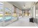 Enclosed sunroom overlooking the pool and backyard with tile flooring and lots of natural light at 13627 Lightning Rod Ct, Hudson, FL 34669
