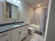 Updated bathroom with granite vanity, white cabinetry, and tiled shower at 1508 Figleaf Ln, Clearwater, FL 33756