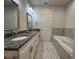 Bathroom features granite counters on the double vanity, a large tub, and marble-style tile at 1508 Figleaf Ln, Clearwater, FL 33756