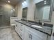 Modern bathroom features double vanity with granite countertop and tiled marble shower at 1508 Figleaf Ln, Clearwater, FL 33756