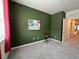 This bedroom features green walls, gray carpet, and unique decorations at 1508 Figleaf Ln, Clearwater, FL 33756