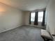 Bedroom features a light neutral paint and gray carpet, with natural light from windows at 1508 Figleaf Ln, Clearwater, FL 33756