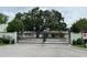 Automatic security gate with stone columns, landscaping, and exterior lighting at 1508 Figleaf Ln, Clearwater, FL 33756